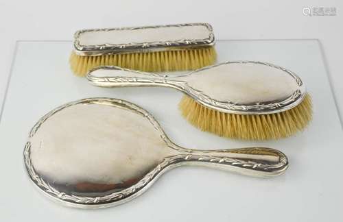 A silver dressing table set, comprising hand mirror, hair brush, and clothes brush, Birmingham,