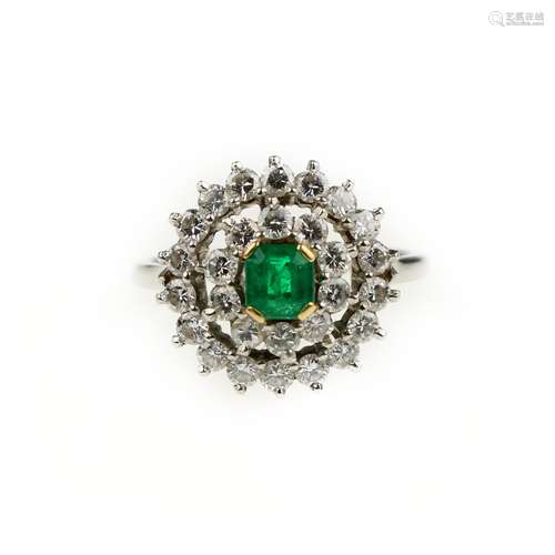 An emerald and diamond cluster ring