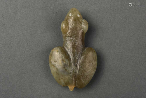 A CELADON AND RUSSET JADE AMULET YUAN DYNASTY BEFORE