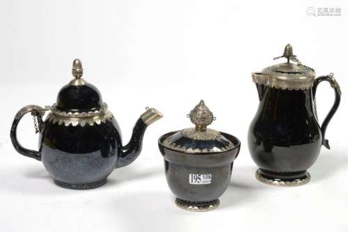 A teapot, a coffee pot and a sugar bowl in black e…