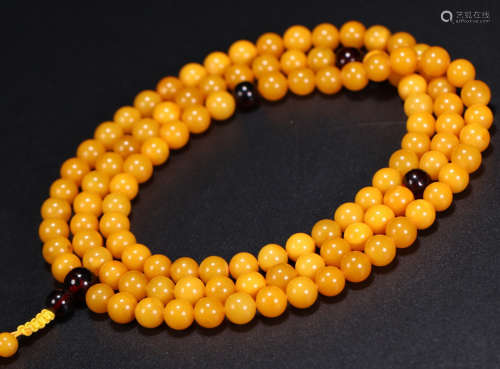 AN AMBER CARVED 108 BEADS STRING NECKLACE