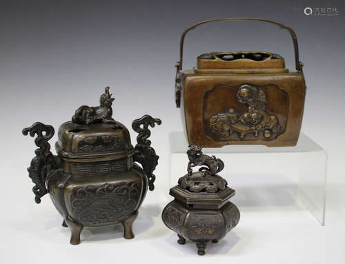 A Japanese brown patinated bronze hand warmer, Meiji period, the oblong body cast in relief with