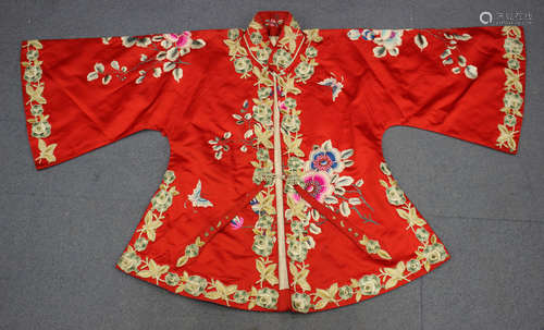 A Chinese red silk embroidered and appliqué jacket, 20th century, worked in coloured threads with