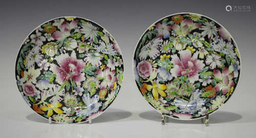 A pair of Chinese famille rose millefleurs black ground porcelain saucer dishes, mark of Qianlong