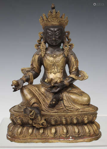 A Sino-Tibetan gilt and brown patinated bronze figure of Jambhala, probably late Qing dynasty, the