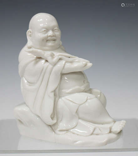 A Chinese blanc-de-Chine porcelain figure of Buddha, 20th century, modelled seated on a rock with