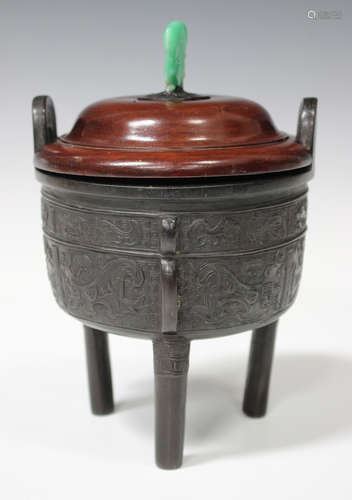 A Chinese archaistic brown patinated bronze tripod censer, the circular body cast in low relief with