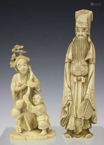 A Japanese carved ivory okimono figure group of an elder and young boy, Meiji period, modelled