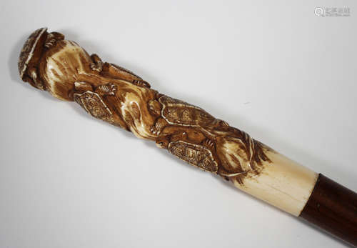 A Japanese ivory handled walking cane, early 20th century, the carved and stained ivory handle