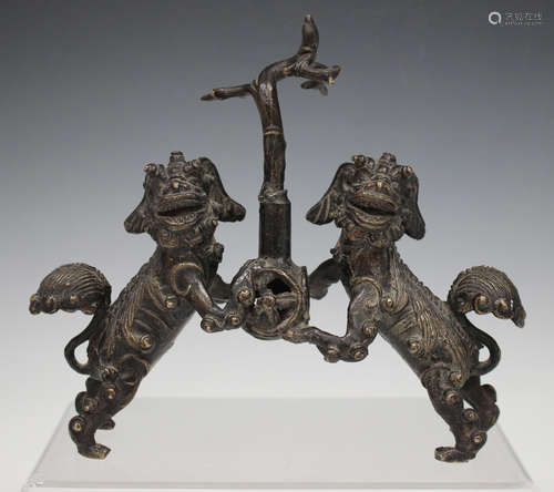 A Chinese brown patinated bronze jostick holder, probably Ming dynasty, modelled as a pair of