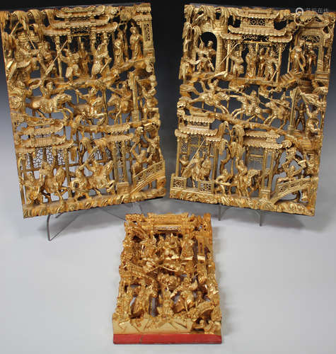 A pair of Chinese carved and pierced giltwood rectangular panels, 20th century, decorated in high