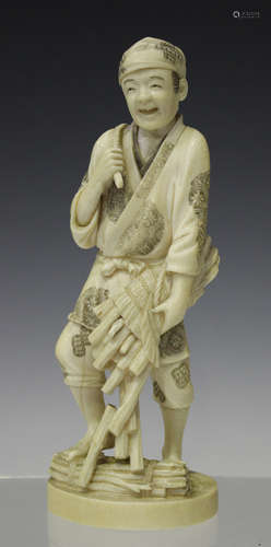 A Japanese carved ivory okimono figure, Meiji period, modelled as a peasant farmer wearing a tunic