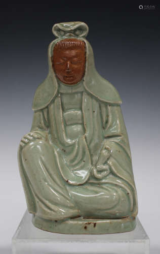 A Chinese Longquan celadon glazed and biscuit stoneware figure of Guanyin, Ming dynasty modelled
