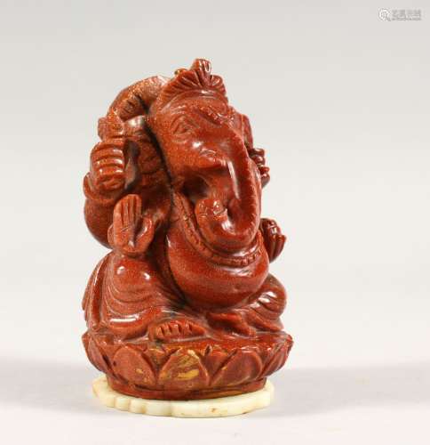 A 20TH CENTURY INDIAN GOLD STONE / GLASS FIGURE OF GANESH, fixed to a carved jade / soapstone