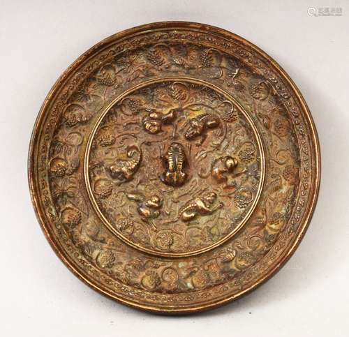 A GOOD 19TH CENTURY OR EARLIER CHINESE BRONZE MIRROR, of circular form, with cast beast and grape