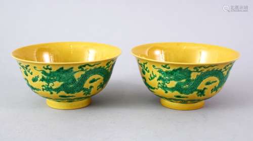 A GOOD PAIR OF CHINESE YELLOW GROUND DRAGON BOWLS, the side of the bows decorated with scenes of