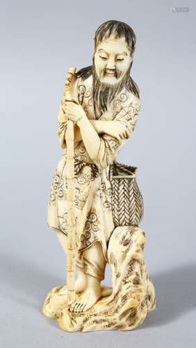 A GOOD JAPPANESE MEIJI PERIOD CARVED IVORY OKIMONO - WAYFAIRER, the man stood leaning upon a