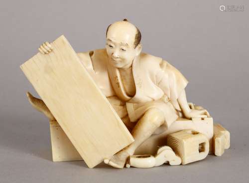 A GOOD JAPANESE MEIJI PERIOD CARVED IVORY OKIMONO OF A WOOD WORKER, the worker seated upon a bench