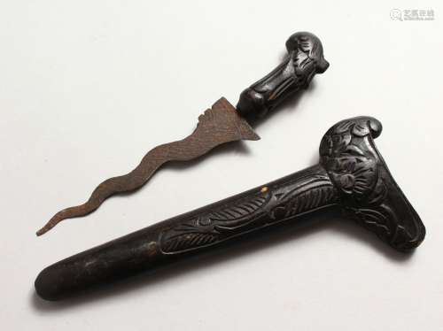 A GOOD 19TH CENTURY INDONESIAN KRIS DAGGER, with a carved wood scabbard, and a carved wood hilt,