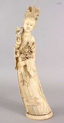 A GOOD 19TH CENTURY CHINESE CARVED IVORY FIGURE OF GUANYIN, stood holding her floral arrangements,