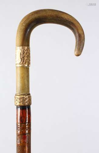 A GOOD 19TH CENTURY RHINO HORN HANDLE WALKING CANE, with a gilt metal collar, the stic with carved