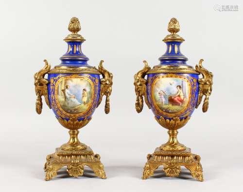 A SUPERB PAIR OF SEVRES PORCELAIN AND ORMOLU URNS AND COVERS, painted with reverse scenes of a young