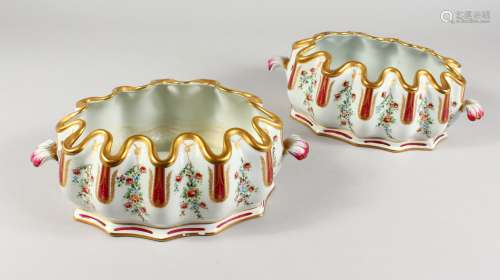 A PAIR OF FRENCH PORCELAIN OVAL SHAPED JARDINIERES, with gilt edges and painted with flowers.