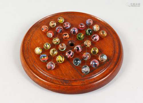 A WOODEN SOLITAIRE BOARD WITH AIR TWIST MARBLES. 8.5ins diameter.