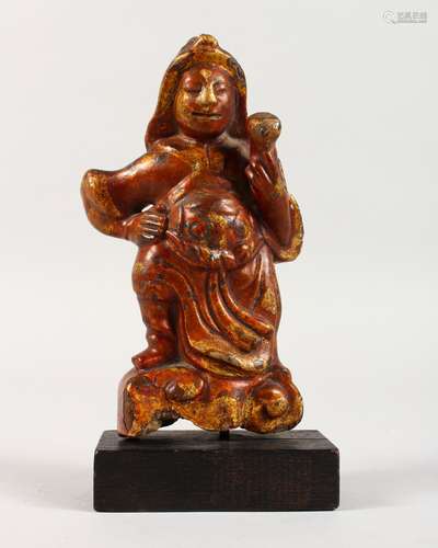 AN UNUSUAL GILDED AND LACQUERED CAST METAL ORIENTAL FIGURE, on a stand. 7.5ins high.