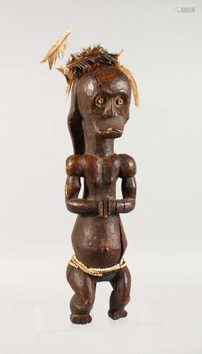 A CARVED WOOD TRIBAL SEATED FIGURE. 18ins high.