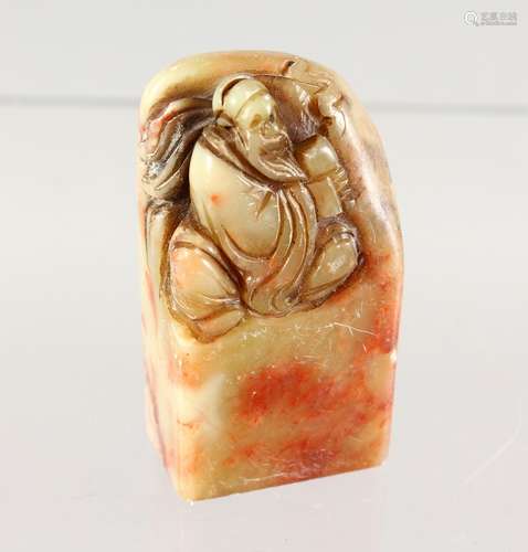 A SOAPSTONE SEAL, carved with a seated man. 2.5ins high.