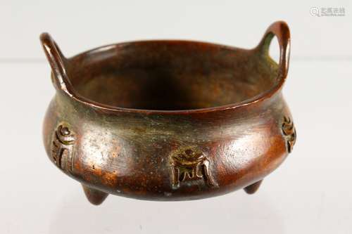 A SMALL CHINESE BRONZE TWIN-HANDLED CENSER, decorated with calligraphy. 3.5ins diameter.