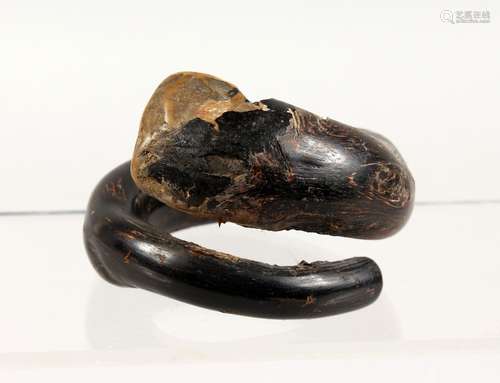 AN UNUSUAL TRIBAL BANGLE, possibly made of black coral. 4ins wide.