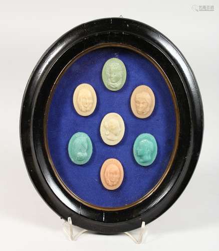 A SET OF SEVEN WAX PORTRAIT BUST SEALS, in an oval glazed frame. 10ins high.