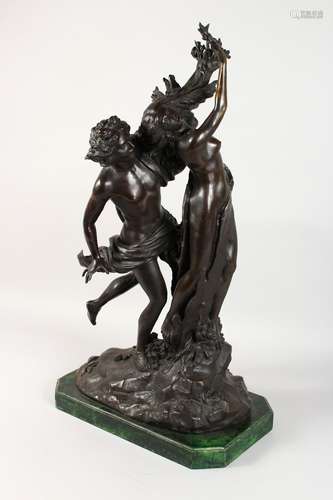 A LARGE BRONZE GROUP, a young man embracing a semi-nude standing female figure, on a shaped green