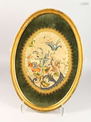 A 19TH CENTURY OVAL SILKWORK FLORAL PICTURE, framed and glazed. 22ins high.