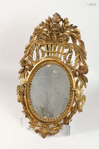 A 19TH CENTURY CARVED GILTWOOD MIRROR, with oval plate, the frame carved with a basket of flowers