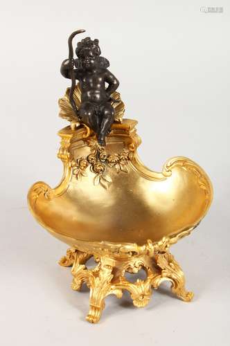 A CLASSICAL STYLE GILT BRONZE TABLE SALT, modelled as a cherub seated on a shell. 7.5ins high.