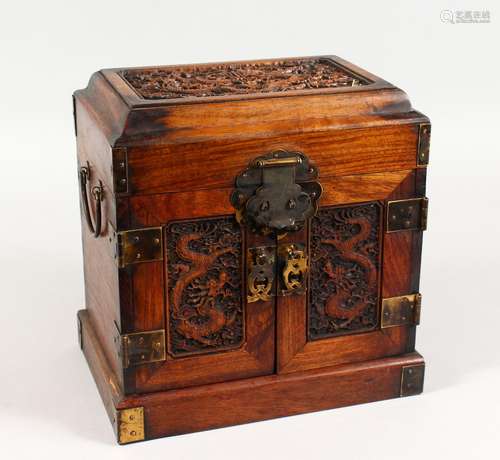 A CHINESE HARDWOOD TABLE CABINET, the hinged top and pair of doors carved with dragons. 10ins wide x