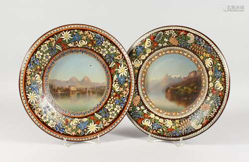 A PAIR OF CONTINENTAL TERRACOTTA CIRCULAR DISHES, each painted to the centre with mountainous