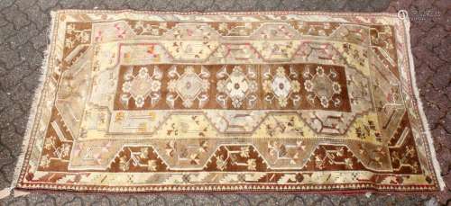 A 20TH CENTURY PERSIAN CARPET, beige ground with large stylised motifs. 8ft 0ins x 4ft 5ins.