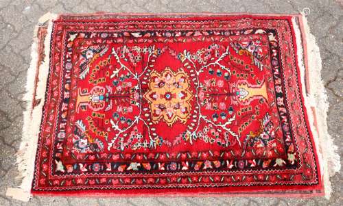 A 20TH CENTURY PERSIAN RUG, bright red ground with floral decoration. 5ft 3ins x 2ft 10ins.
