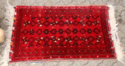 A SMALL 20TH CENTURY PERSIAN RUG, crimson ground with three rows of geometric medallions. 3ft 9ins x