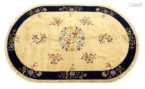 A GOOD CHINESE OVAL CARPET, beige ground with floral decoration, within a similar blue ground