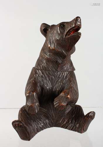 A BLACK FOREST CARVED WOOD SEATED BEAR CADDY. 8ins high.