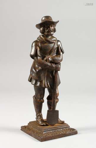 A CAST METAL FIGURE OF A MAN LEANING ON A SPADE. 7.25ins high.