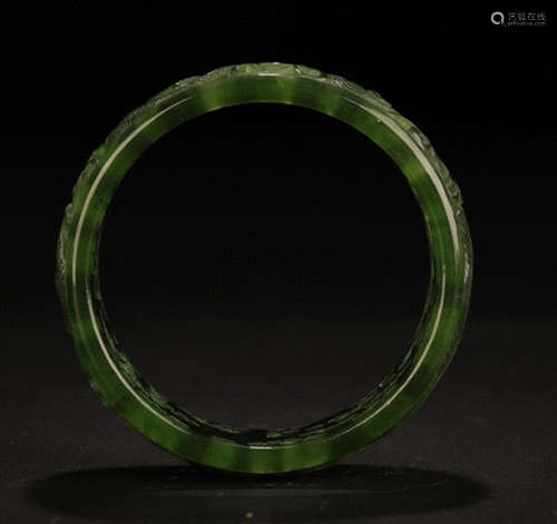 A GREEN JADE BANGLE CARVED WITH PHOENIX AND DRAGON