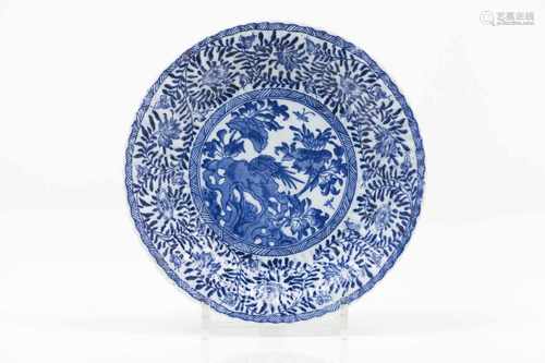 A scalloped plateChinese porcelainBlue underglaze decoration of central bushes, flowers, ro