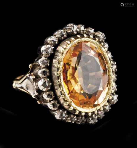 A ringSilver and goldSet with synthetic yellow sapphire framed by small rose cut diamondsb