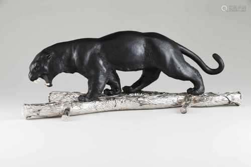 A pantherBronze and silver sculpture on a raised and engraved silver tree branchBone teeth